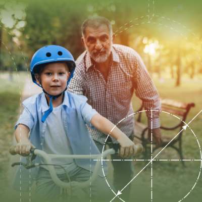 grandfather holding young boy on bike